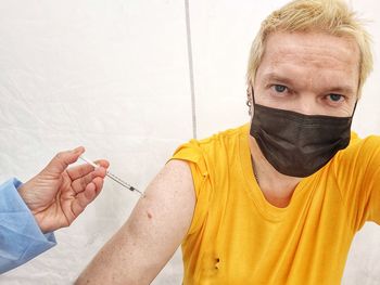 Portrait of a young man holding yellow camera