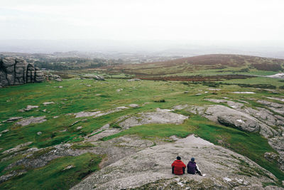 Rear view of people on cliff against mountains