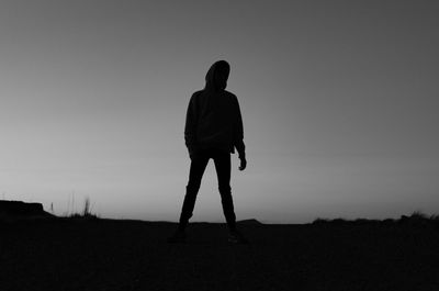 Silhouette man standing on field against sky