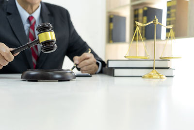 Midsection of man holding camera on table