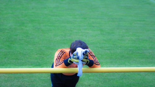 High angle view of man leaning on railing at playing field