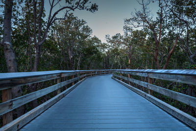 Footbridge over river against sky