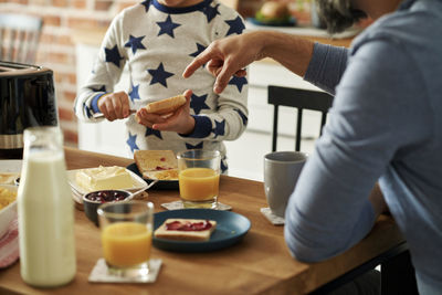 Midsection of man holding coffee on table