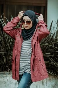 Portrait of young woman wearing sunglasses standing outdoors