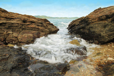 Scenic view of rocks in sea against sky