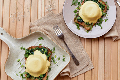 Vegan alternative eggs benedict with plant-based sauce, sourdough bread, tofu, onion,  pea sprout. 