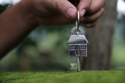 Close-up of person holding hands hanging on metal