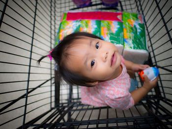 High angle portrait of girl sitting in shopping cart