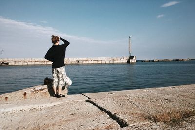 Full length of woman standing at promenade against sky