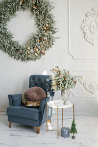 Classic christmas living room interior. a blue armchair with pillows, a wreath on the wall christmas