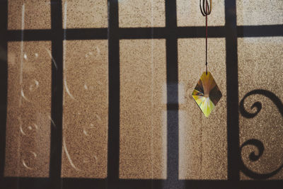 Close-up of window with bars and a hanging crystal