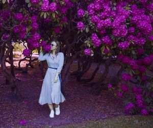 Young woman smelling flowers growing on tree