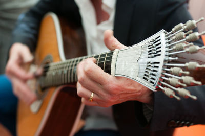 Midsection of man playing guitar