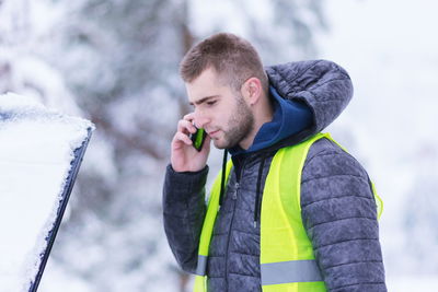 Young man using smart phone during winter