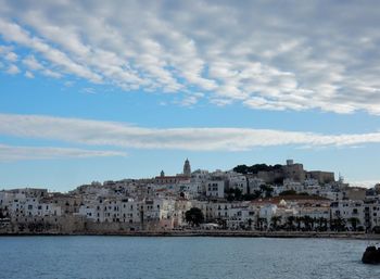 Buildings in city against cloudy sky