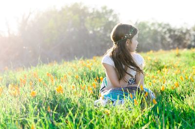 Woman sitting on grass during sunny day