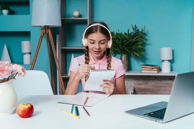 Smiling girl writing in diary at home