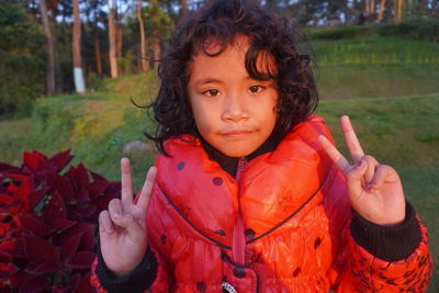 Portrait of young woman gesturing peace love symbol