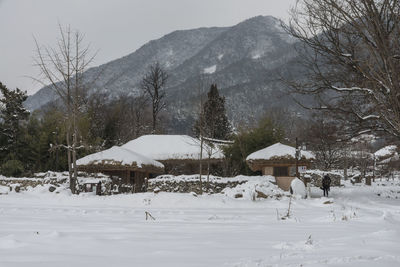 Houses on snowcapped mountains against sky