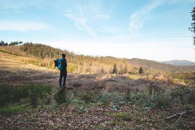 Traveller with a blue backpack on his back walks towards his unforgettable experiences in beskydy