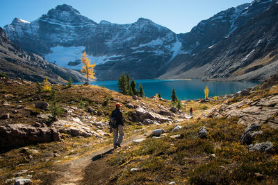 Rear view of man walking against mountains