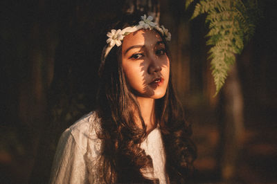 Portrait of young woman looking away outdoors