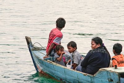 Rear view of people sitting in boat