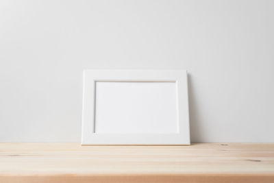 Close-up of empty table against white wall