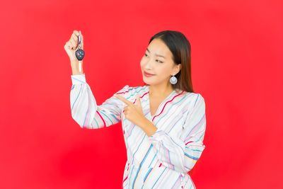 Full length of woman standing against red background