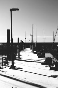 Street lights on pier against clear sky