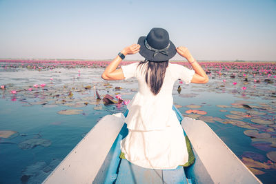 Asian tourist woman on a blue long tail boat at amazing red lotus sea. unseen in thailand.