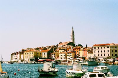 Boats moored at dock against clear sky