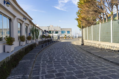 Footpath amidst buildings against sky