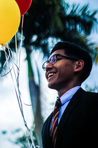 Portrait of smiling boy against tree