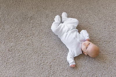 High angle view of baby lying down on floor