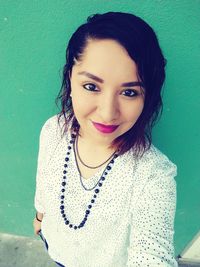 Portrait of beautiful woman standing against wall