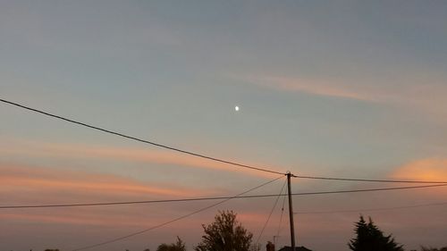 Silhouette of electricity pylon at dusk