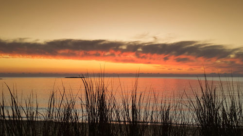 Scenic view of sea against romantic sky at sunset