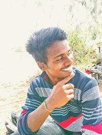 Portrait of smiling young man sitting outdoors