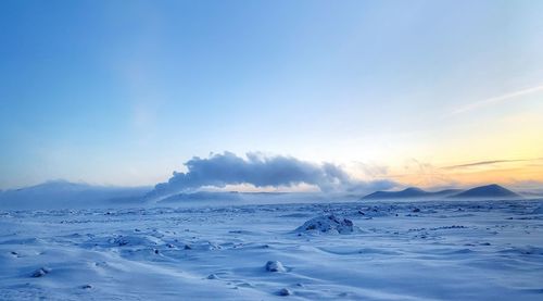 Scenic view of snowcapped mountains against sky during sunset