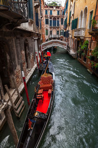 High angle view of gondola moored in canal amidst buildings