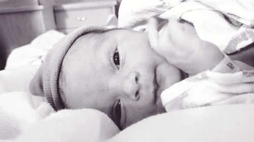 Close-up portrait of cute baby lying on bed