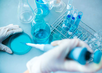 High angle view of hand holding blue glass