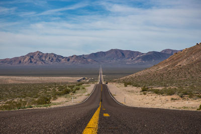 Country road leading towards mountains in death valley