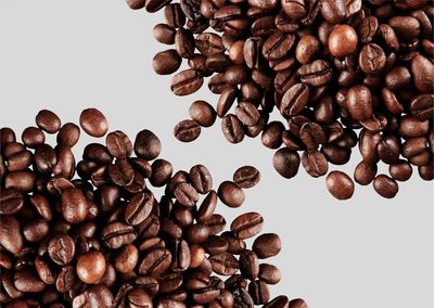 Close-up of roasted coffee beans against white background