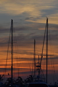 Silhouette of sailboats at harbor during sunset