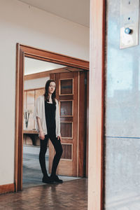 Portrait of woman standing at doorway