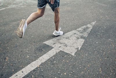 Low section of man running on road