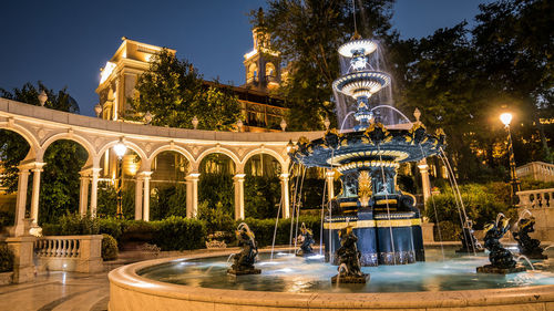 Low angle view of fountain in city at night