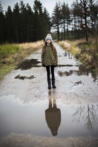 Portrait of girl standing on wet road